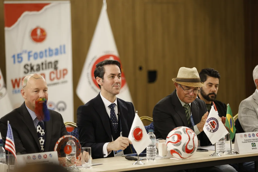 Delegates of the FIFS World Congress 2024 seated with their national flags on the table