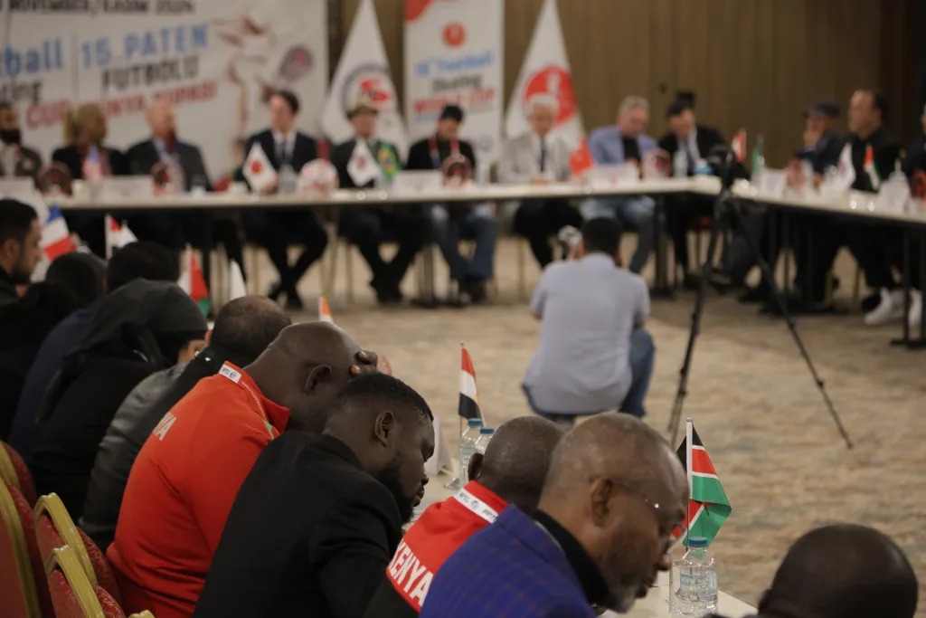 National federation representatives seated around the FIFS Congress table with their flags