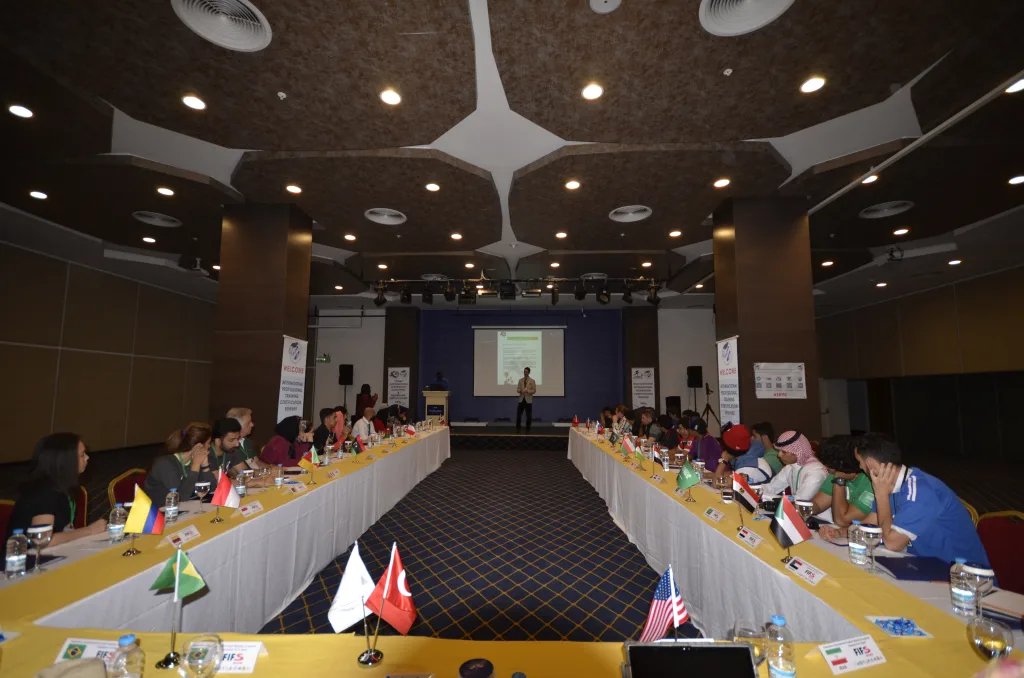 An international FIFS and IPTC coaching seminar with national flags around the table