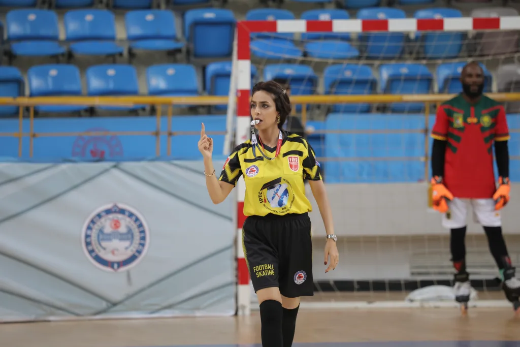 A woman referee signalling a decision during an international Football Skating match
