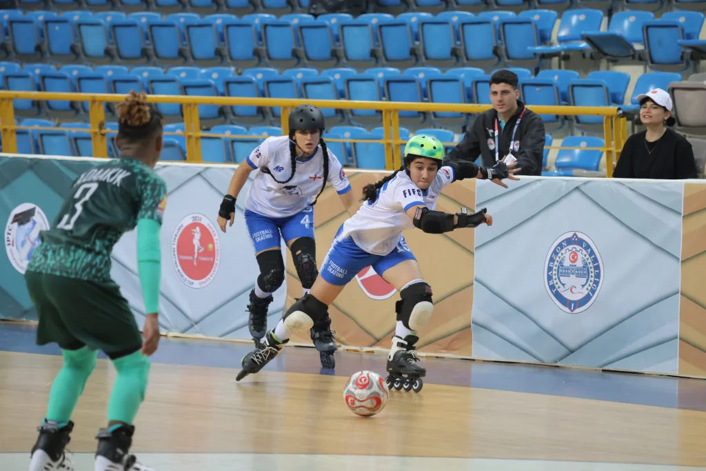 Women players competing for the ball on inline skates during international Football Skating competition