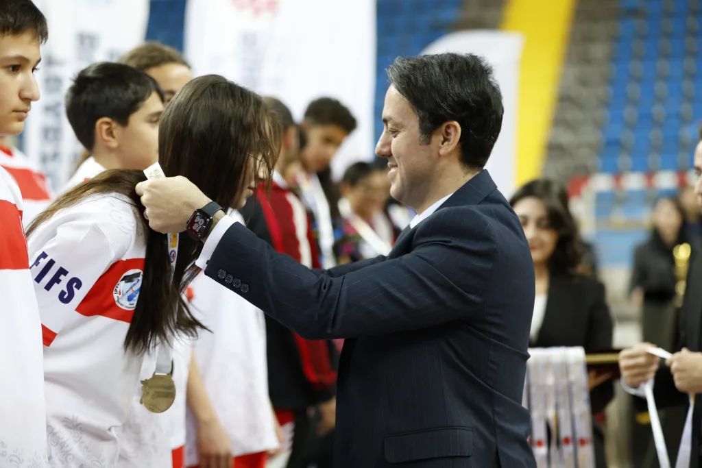 A young athlete receiving a medal at the Junior Football Skating World Cup ceremony