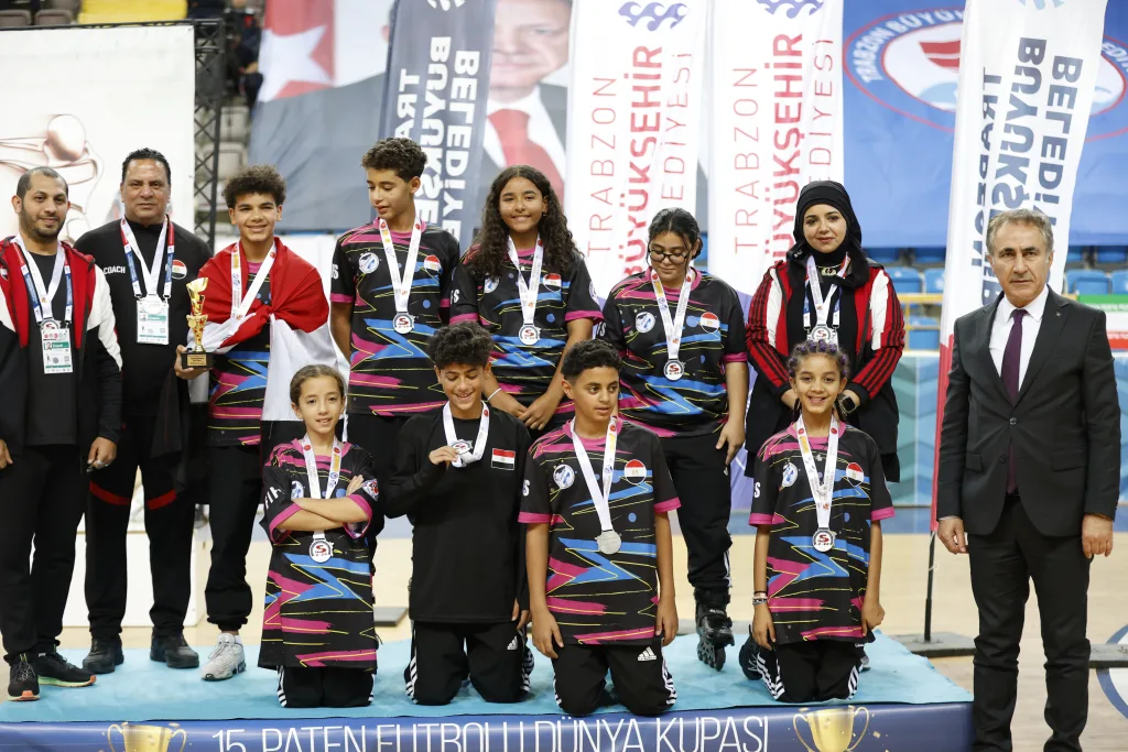 A junior national team with their medals on the podium of the first Junior Football Skating World Cup