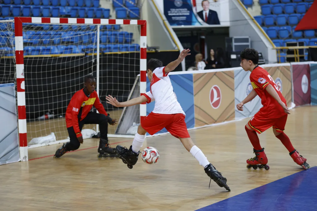 A school-age player shooting at goal on inline skates during a Football Skating match