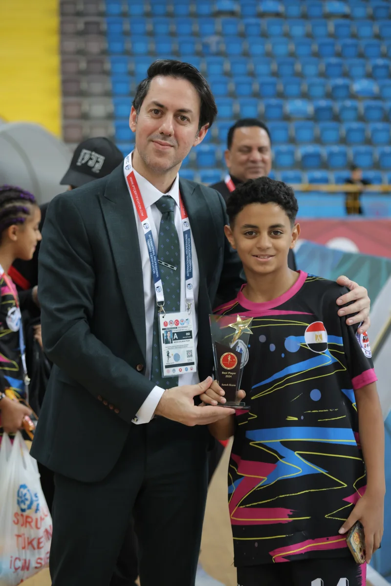The FIFS President presenting an award to a young Football Skating athlete