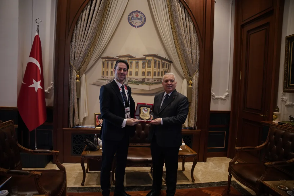 The FIFS President and a national government representative exchanging official gifts during a formal meeting